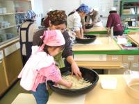 母と子でそば粉をこねている写真