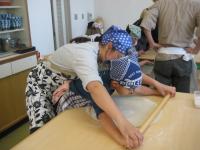 親子で一緒に生地を延ばしている写真