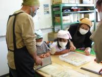 父が包丁で切っているのを一家で見守っている写真