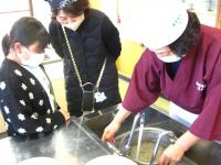 蕎麦のゆで方を教わる親子の写真