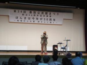 ハーモニカ奏者のトンさんがステージ上で曲を演奏している様子