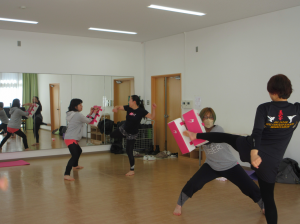 二人組になりマットめがけてキックする受講生