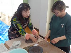 講師先生から手ほどきを受けるお母さん