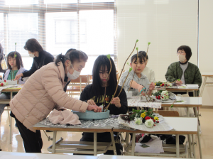 あじさいを七宝へ角度をつけて活ける指導をする講師先生