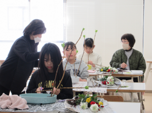 子ども達が活けたお花を見ながら指導にあたる講師先生