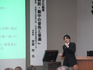 レトロな蓄音機を操作して戦前のレコードを流す講師先生