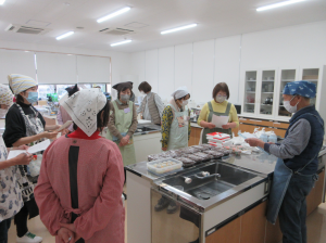 講師料理台の周りに受講生を集め今日の調理手順を説明する講師先生