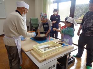 スタッフとともにそば粉をこねる児童