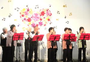 ステージでハーモニカを吹いている会員