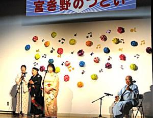 ステージの上で三味線に合わせて民謡を歌う会員