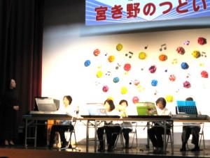 ステージでピアノを弾いている会員