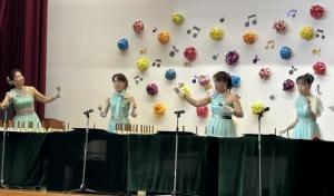 舞台の上でハンドベルを演奏している演者