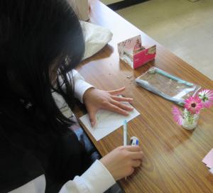 花瓶に生けた花を鉛筆で下書きしている様子
