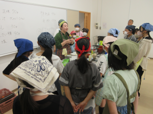 調理台の周りに子ども達を集めて今日の料理の作り方の手順及び注意事項等を話す講師先生