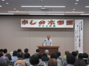 舞台演台前で開講にあたっての挨拶をする教育部長