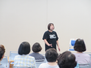 舞台中央に立ち動きの説明と期待される効果をお話しされている講師先生
