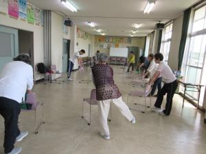 椅子を使って足を動かしながら体操している様子