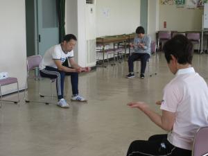 講師と一緒に指の体操をしている様子