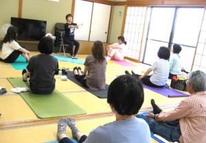 椅子に座ったままの体操を指導する講師