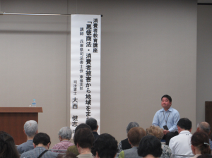 講師紹介を受ける講師先生と演題の垂れ
