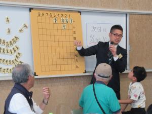講師が大きな将棋盤を使って基本的な説明をしているところ