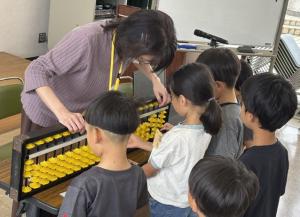 大きなそろばんを使って習う生徒たち
