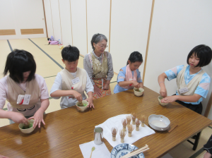 所作に慣れるため机の上でお茶をたてている子ども達