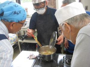 鍋帽子での保温余熱調理で完成したスープを確認する受講生
