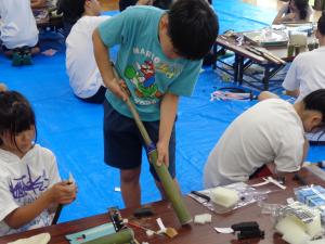 押し棒の先に改良を加える男の子