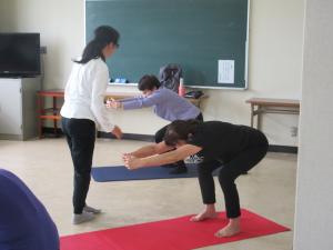 中腰で腕と腰を伸ばし体を引っ張っている様子