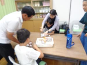 お母さんに手伝ってもらいながらペットボトルを切る様子