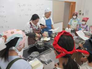 子ども達を講師調理台前に集め今日のポイントを説明する講師先生
