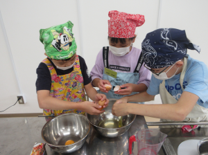 班で協力してボールに卵を割り入れる子ども達