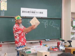 ２枚の板を直角に組み合わせて組み立て方を指導される小川先生