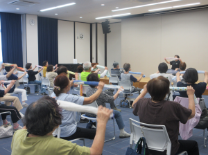 細長く丸めたタオルを両手に持ち、リズムに合わせて握る離すのトレーニングをする受講生の皆さん
