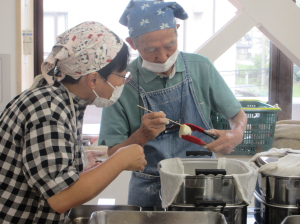 蒸しかげんをチェックする方法を教える講師先生