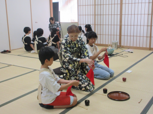 先生のお手本を真剣に見入っているお運び·半月班の子ども達