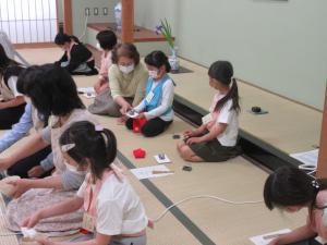 小学生がお茶菓子のいただき方を教わっています