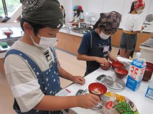 子供が調味料の分量を量っている様子