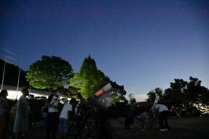 参加者が順番に天体望遠鏡で星を観察する様子
