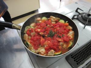 フライパンでチキンのトマト煮を作っている写真
